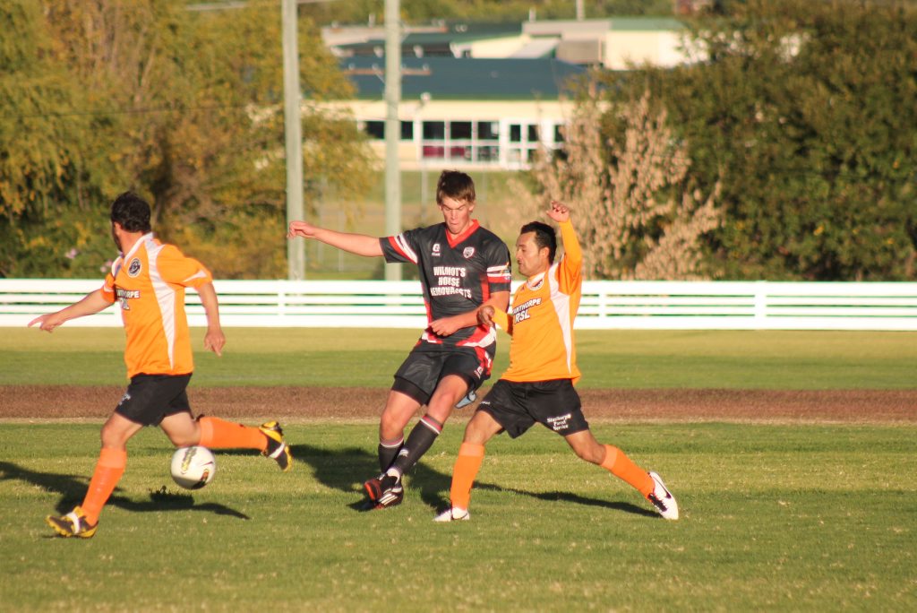 TEAM PLAY: Men's City players Geoff Patti and Romeo Salazar work together to get posession of the ball from United opponent George Merritt. TEAM PLAY: Men's City players Geoff Patti and Romeo Salazar work together to get posession of the ball from United opponent George Merritt.